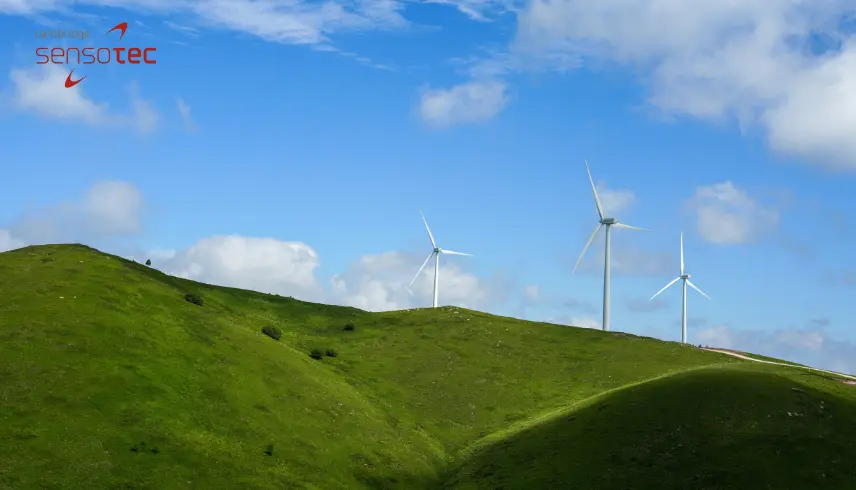 Wind turbines on green hill tops.